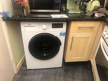 Utility area with new vinyl flooring, integrated washing machine and timber units